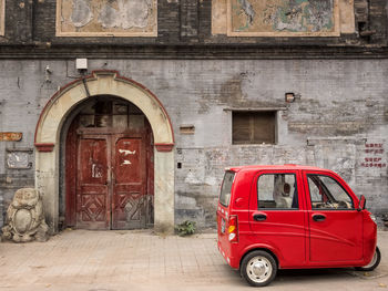 Red vintage car on street against building