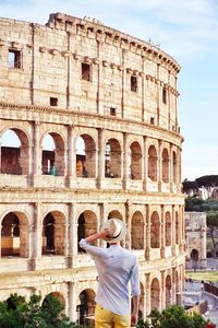 Rear view of mid adult man looking at historical building