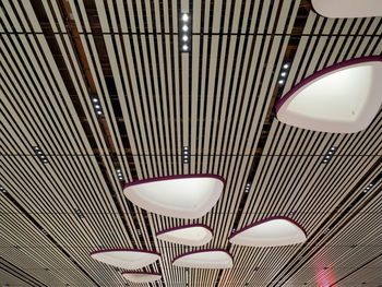 Low angle view of illuminated pendant lights hanging from ceiling