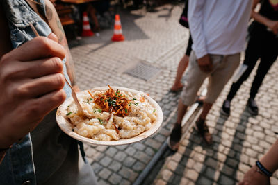 Midsection of woman eating food on street