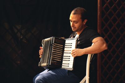 Smiling musician playing accordion on stage