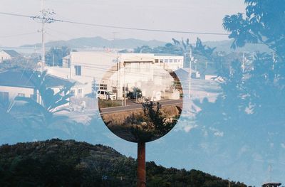 Reflection of buildings on mountain against sky
