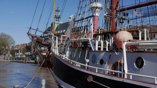 Sailboats moored at harbor against sky