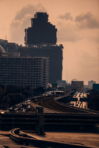 High angle view of railroad tracks by buildings against sky during sunset