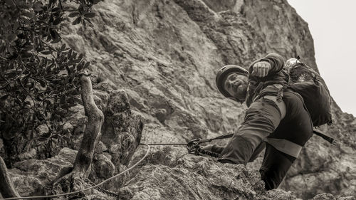 Side view of man climbing on rocky mountain