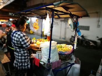 Side view of woman selling food outdoors