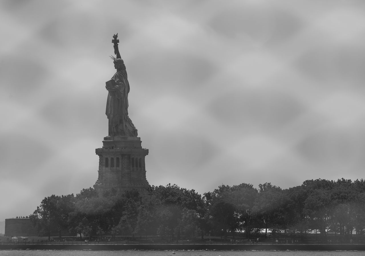 LOW ANGLE VIEW OF STATUES AGAINST CLOUDY SKY