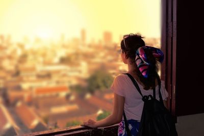 Rear view of woman looking through window