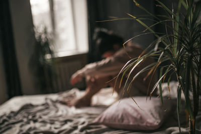 Close-up of woman relaxing on bed at home