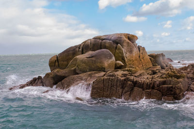 Rock formation in sea against sky