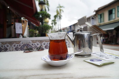 Close-up of tea cup on table against building