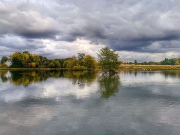 Scenic view of calm lake against cloudy sky