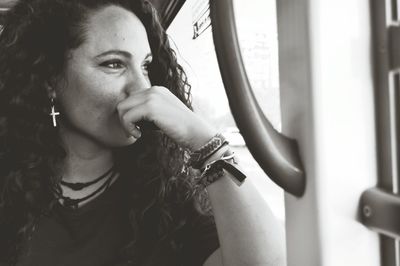 Young woman looking through window while traveling in bus