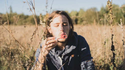 Portrait of woman holding ice cream on field