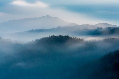 Scenic view of trees and mountains against sky