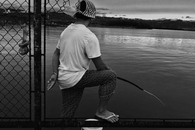 Rear view of man standing at shore