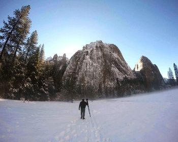 Man standing on snow covered mountain against sky