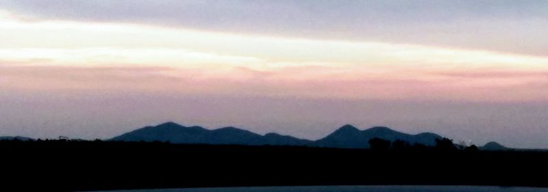 Silhouette landscape against sky during sunset