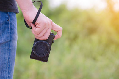 Midsection of person holding camera