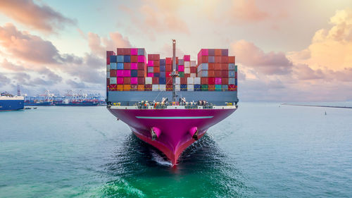 Digital composite image of ship on sea against sky during sunset