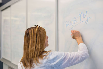 Businesswoman writing on whiteboard in office