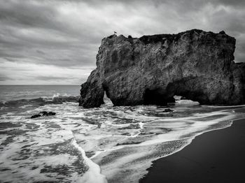 Rocks on beach against sky