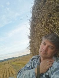 Portrait of mature man on field against sky