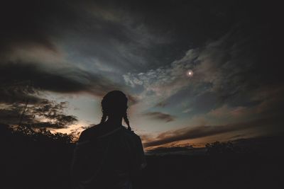 Silhouette of people standing against sky at dusk