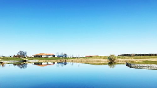 Scenic view of lake against clear blue sky