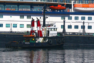 Boats moored at harbor against sky