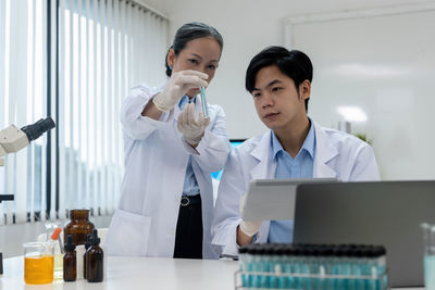 Female doctor examining chemical in laboratory