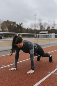 Woman doing press-ups at running track