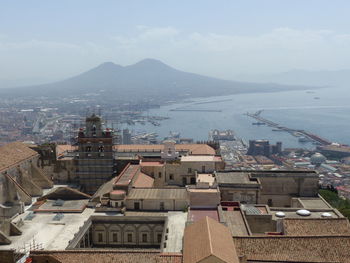 High angle view of townscape by sea against sky