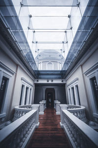 Rear view of man walking on staircase in building