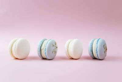 White and blue macaroons on the table, macaroons on pink background. high quality photo