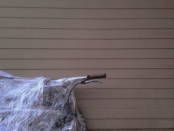 Close-up of umbrella on wood against wall