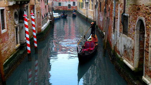 Boats in canal along buildings