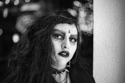 Close-up portrait of young woman with make-up on face at night