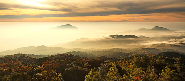 Scenic view of mountains against dramatic sky during sunset