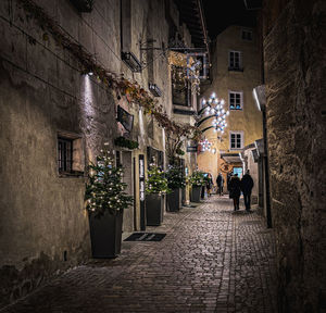 Rear view of man walking on street at night