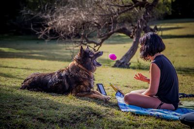 Rear view of woman with dog on field