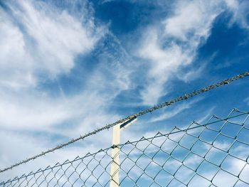 Low angle view of chainlink fence against sky