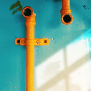 Close-up of yellow pipe on wall