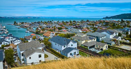 High angle view of townscape by sea against sky