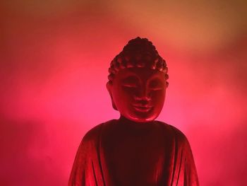 Close-up of statue against red background