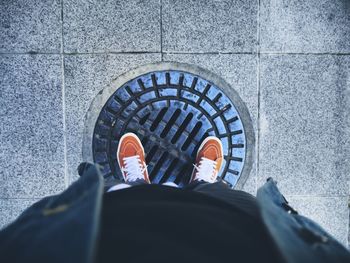 Low section of person standing on tiled floor