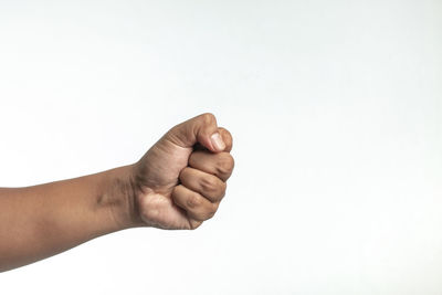 Cropped image of hand clinching fist against white background