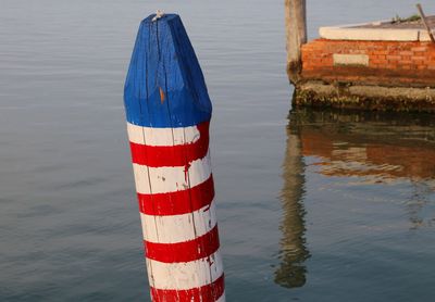 Red wooden post in lake