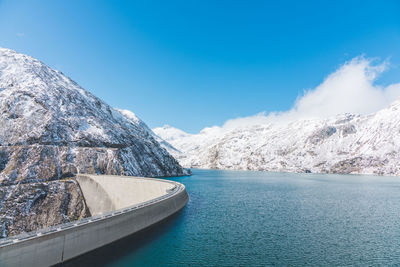 Scenic view of snowcapped mountains against blue sky