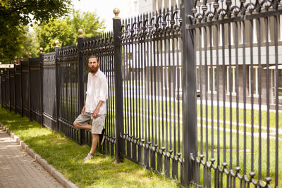 Rear view of woman standing by fence